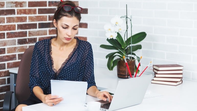 Mujer joven observando un certificado de dominio vigente en propiedades